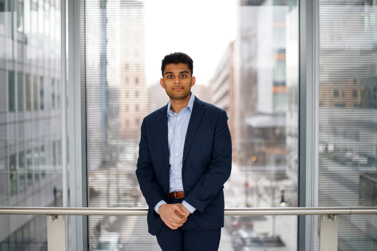 Vishal Patel standing in front of a large window.