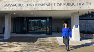 Ingrid Bassett in front of a Massachusetts Department of Public Health building.