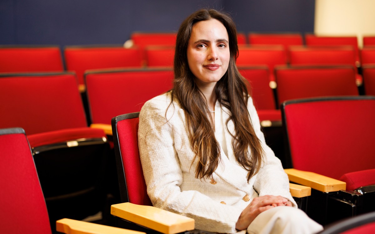 Luiza Lima Vieira sitting in a red theater seat.