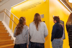 Members of the Troper Wojcicki family view a quote inscribed on the wall of the SEC leading to the Susan Wojcicki Library. The quote reads, "From phones to cars to medicine, technology touches every part of our lives. If you can create technology, you can change the world." 