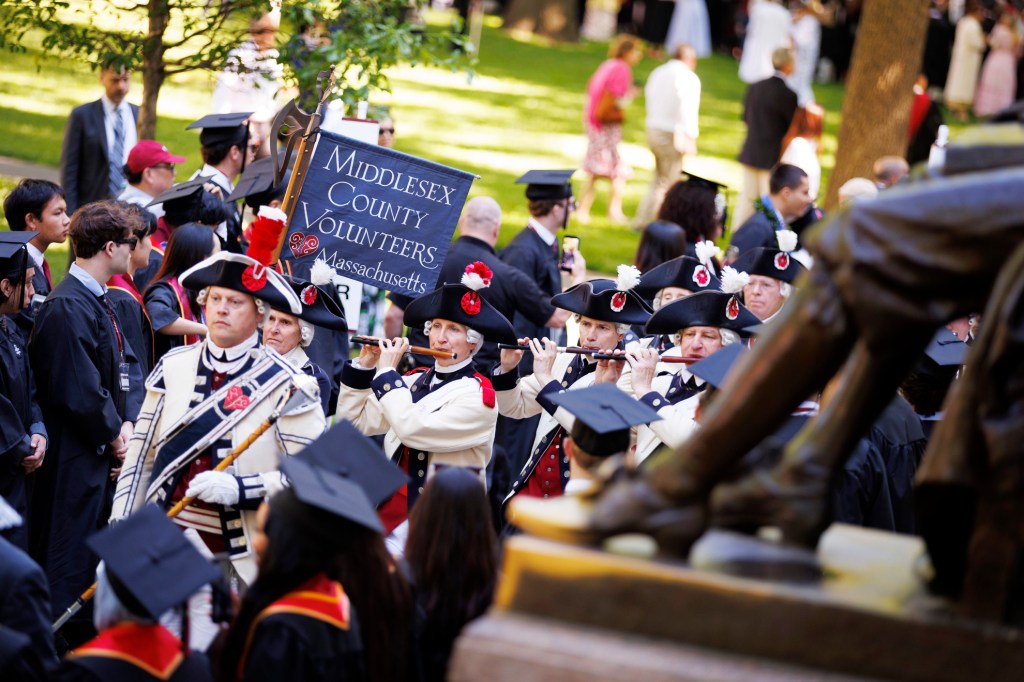 John Nichols, a Harvard employee, leads his group, the Middlesex County Volunteers Fifes & Drums, into Harvard Yard as