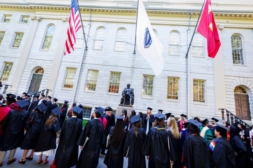 Students line up at the John Harvard Statue for the procession