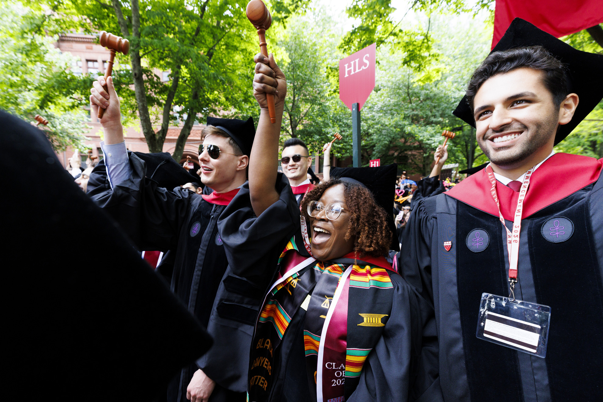 Harvard Law School graduate Tia Patrick (center) cheers as her school is recognized.