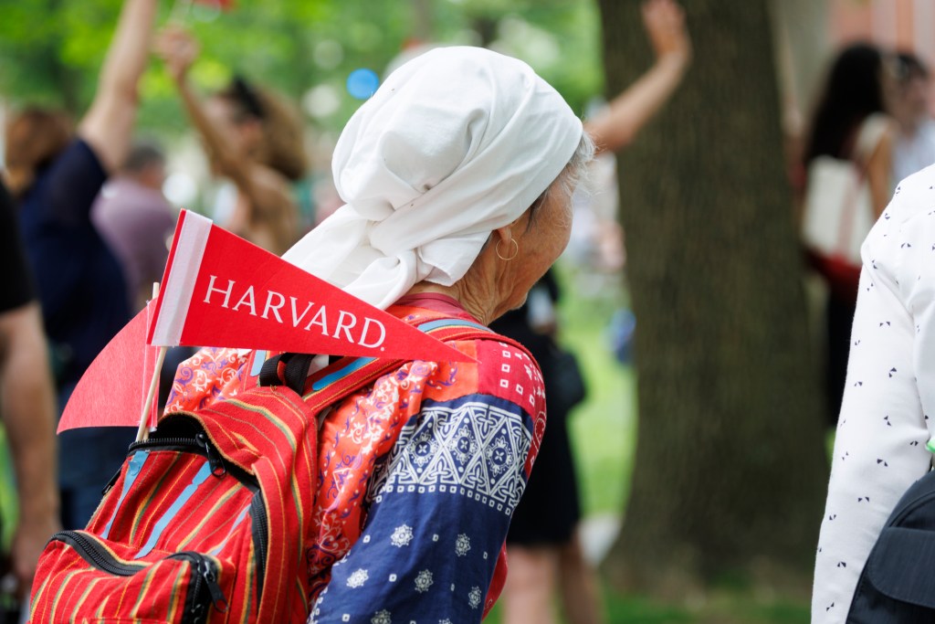 A Harvard pennant sticks out of an attendee’s backpack during Alumni Day, 2025.