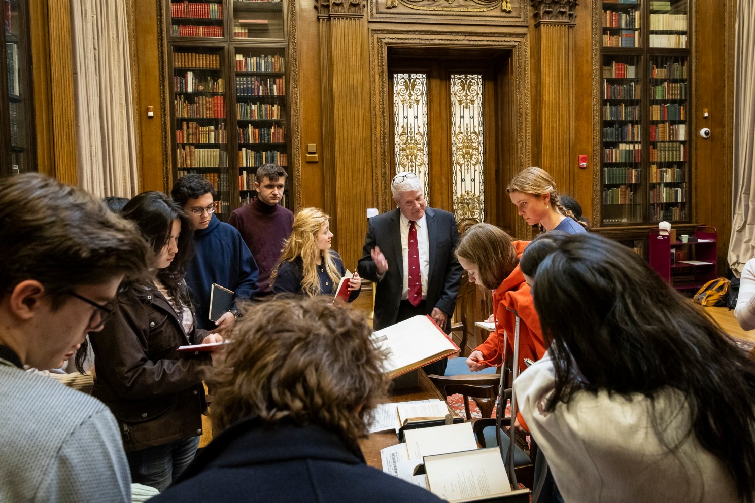 Peter Accardo speaks to students and share texts on display in the Widener Memorial Room.