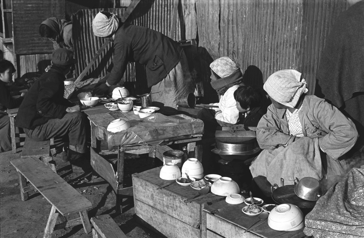 Women serve food at a makeshift restaurant.