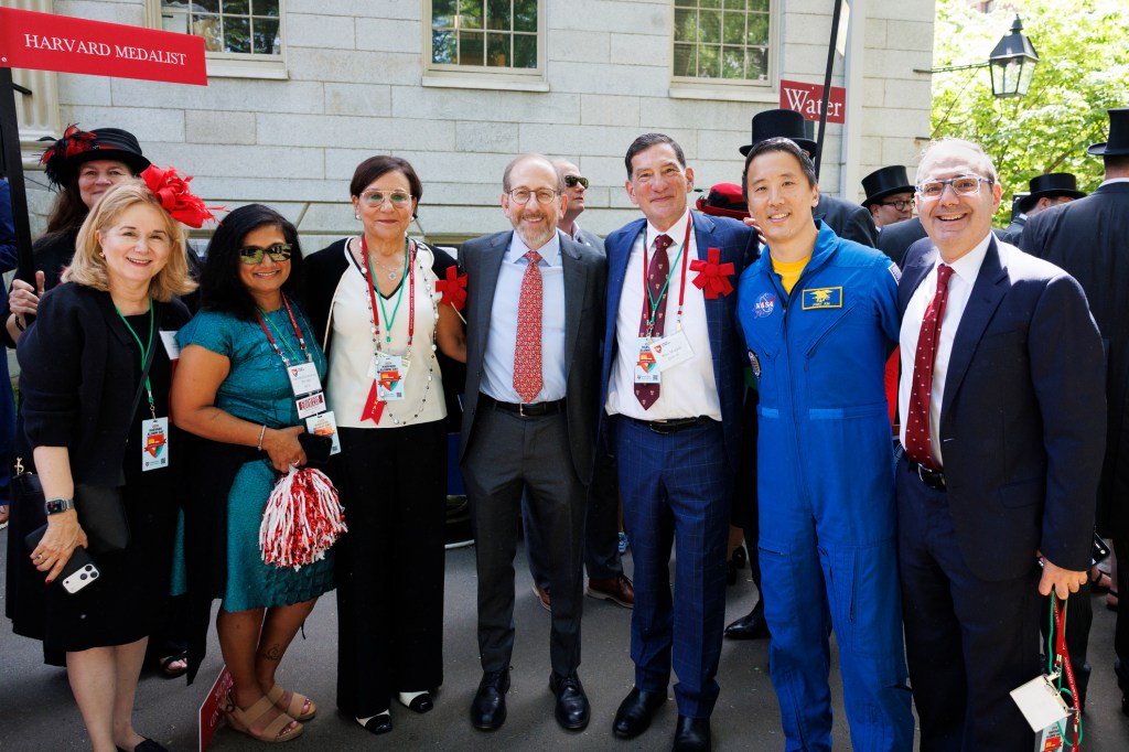 Cynthia A. Torres AB ’80, MBA ’84 (from left); Moitri Chowdhury Savard AB ’93; Penny Pritzker, Senior Fellow of the Harvard Corporation; Alan Garber, President of Harvard University; Will Makris EdM ’00, President of the Harvard Alumni Association; Jonny Kim MD ’16, Harvard Alumni Day Speaker; and David Battat AB ’91, Incoming HAA President; pose for a photo during the parade on Harvard Alumni Day 2026