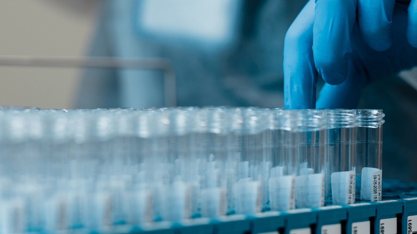 Lab technician pulls test tubes of specimens.