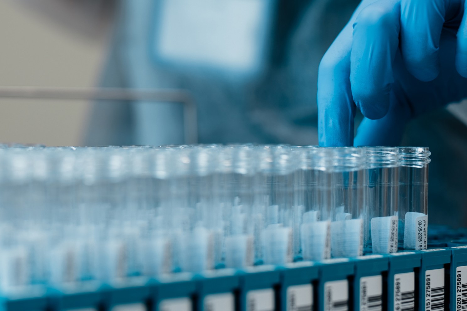 Lab technician pulls test tubes of specimens.