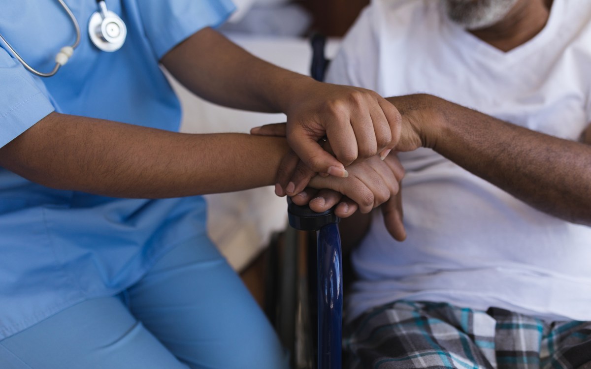 Young healthcare worker assisting an older patient.