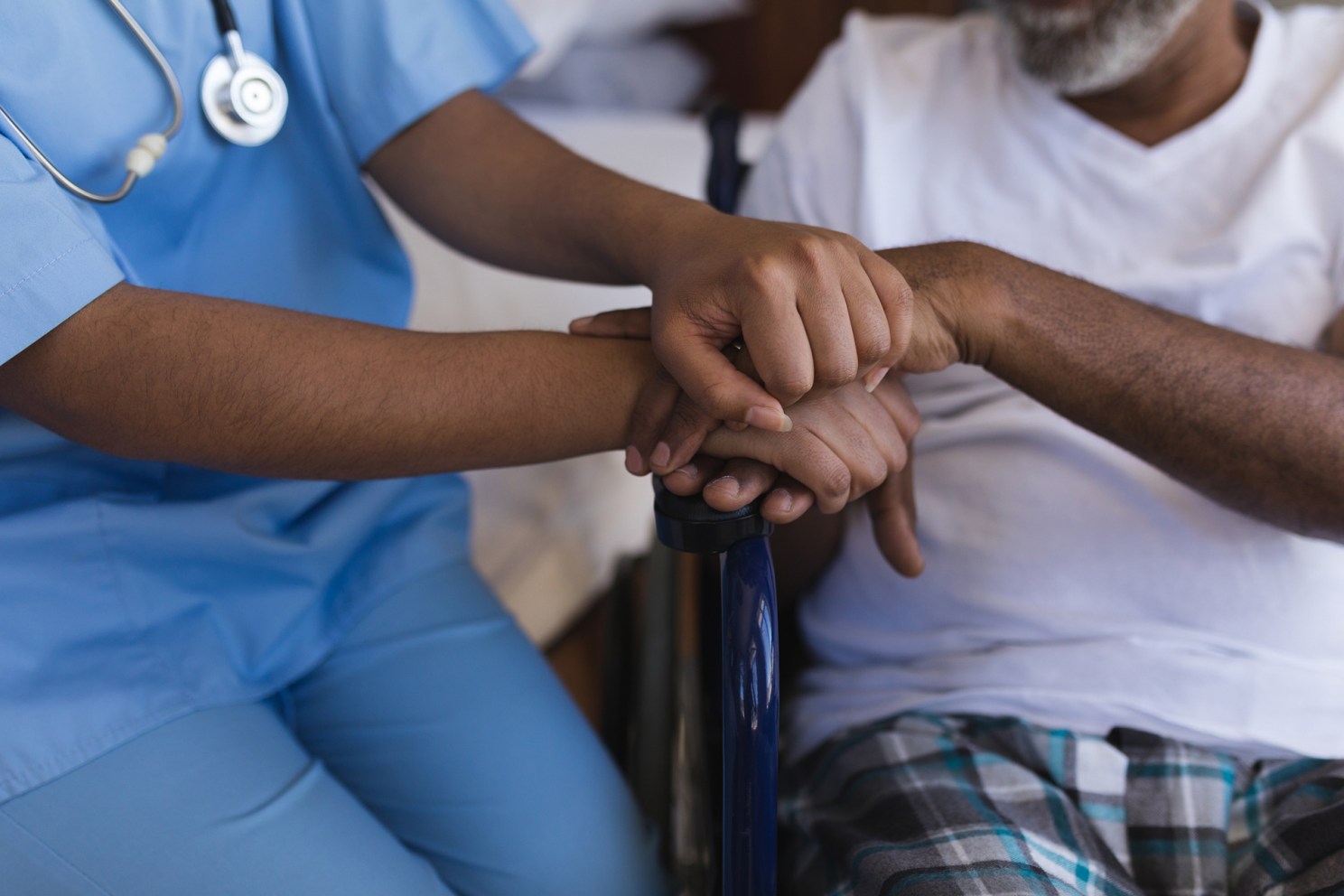 Young healthcare worker assisting an older patient.