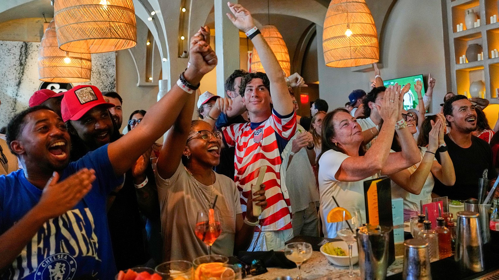 Soccer fans cheer together in a bar as they watch a World Cup soccer match between U.S. and Bosnia in Los Angeles.