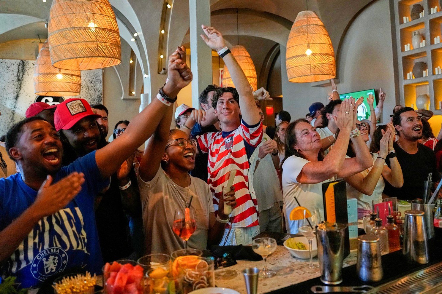 Soccer fans cheer together in a bar as they watch a World Cup soccer match between U.S. and Bosnia in Los Angeles.