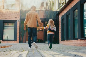 Parent walking with child into school.