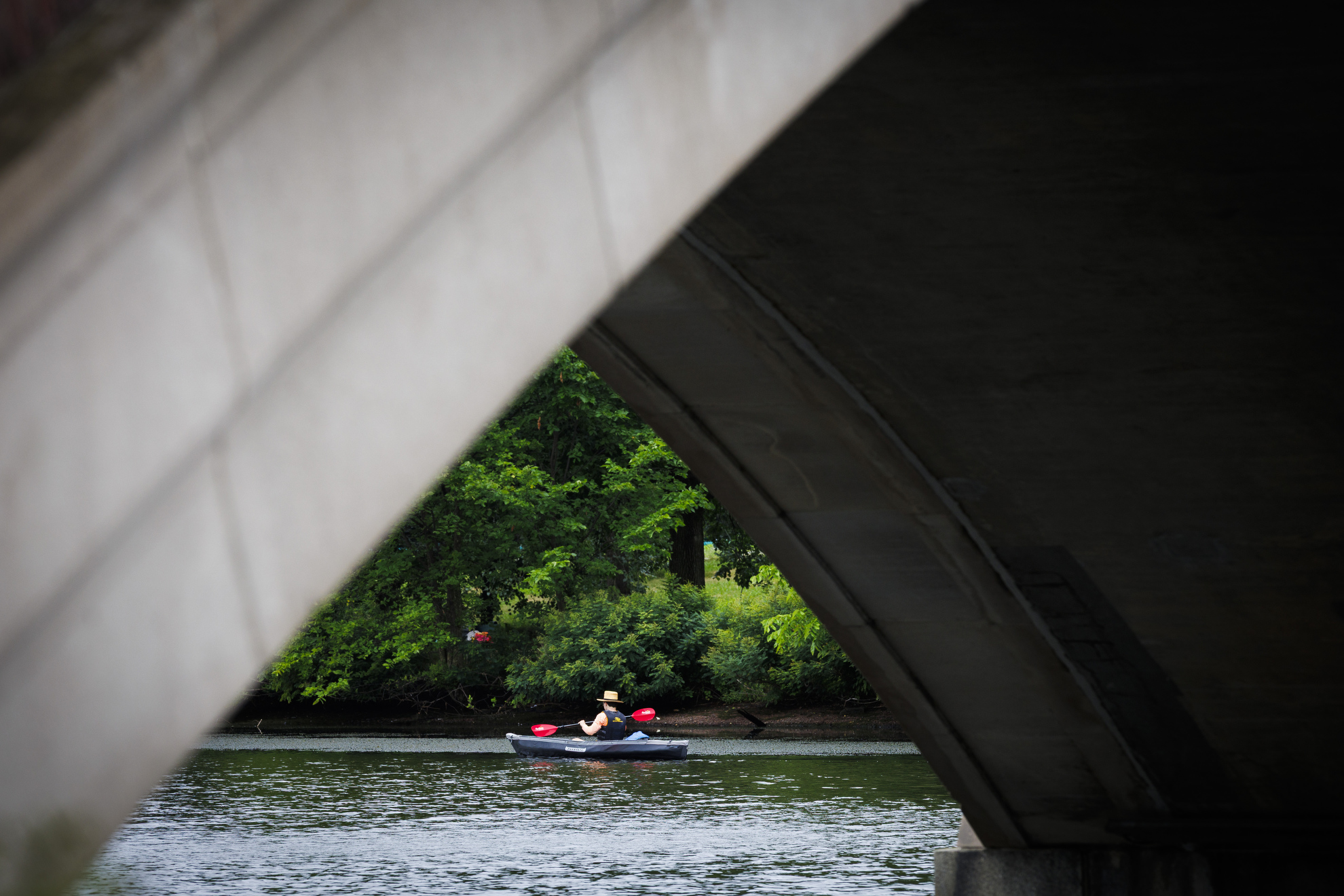 A kayaker makes their way down river.