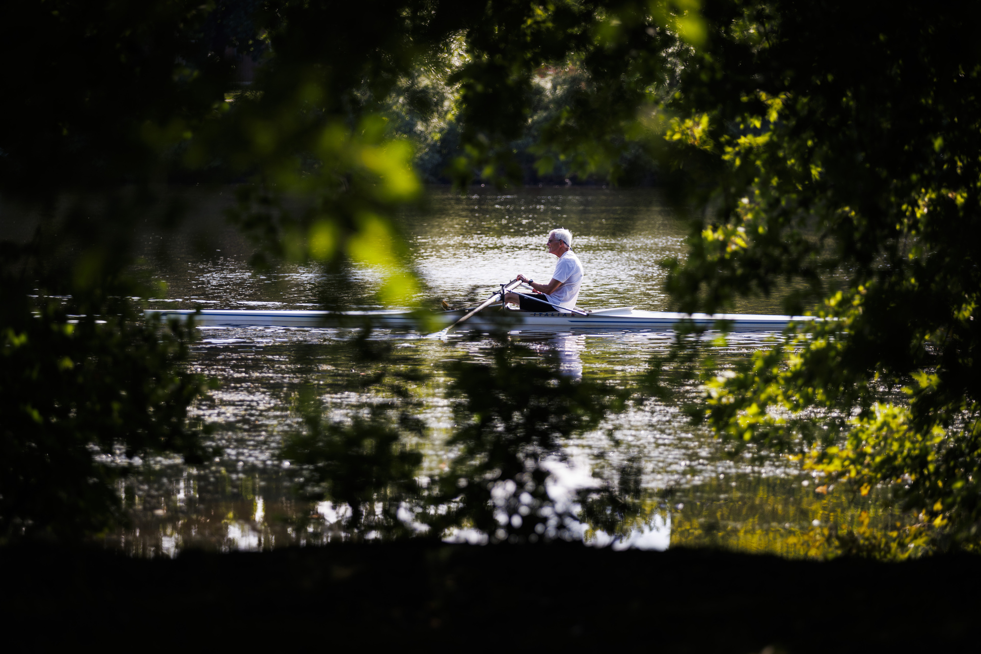 A rower makes their way down river.