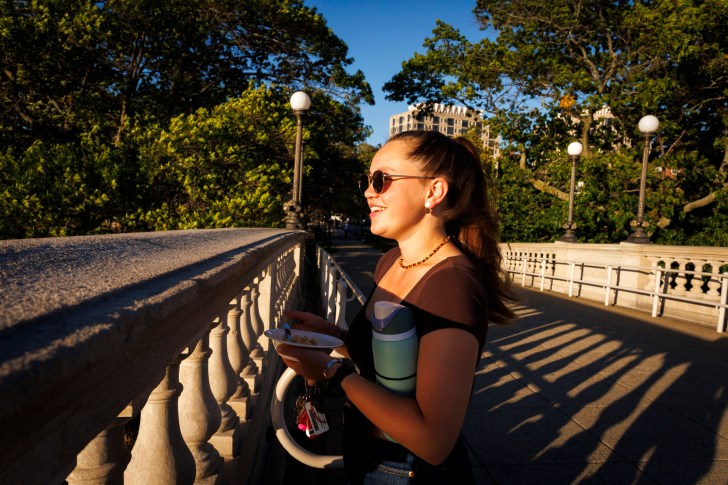 Micah John '28 enjoys the sunset view from the Weeks Footbridge.