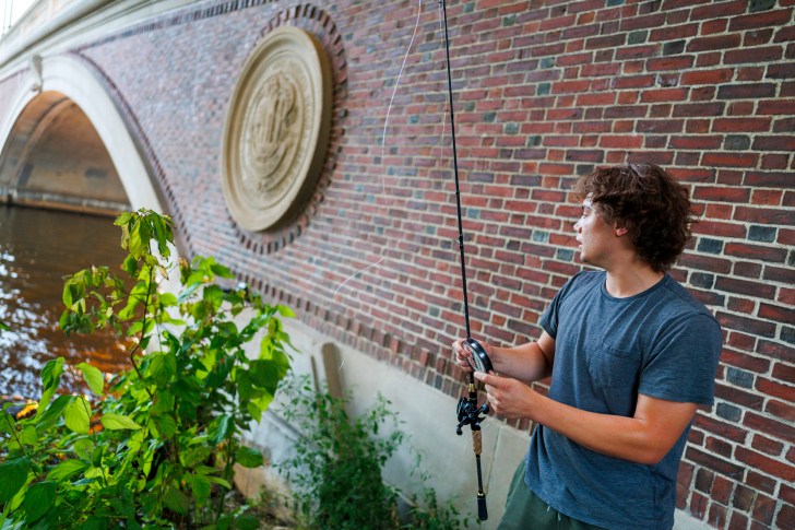 Omar Silas fishes alongside the Weeks Footbridge.