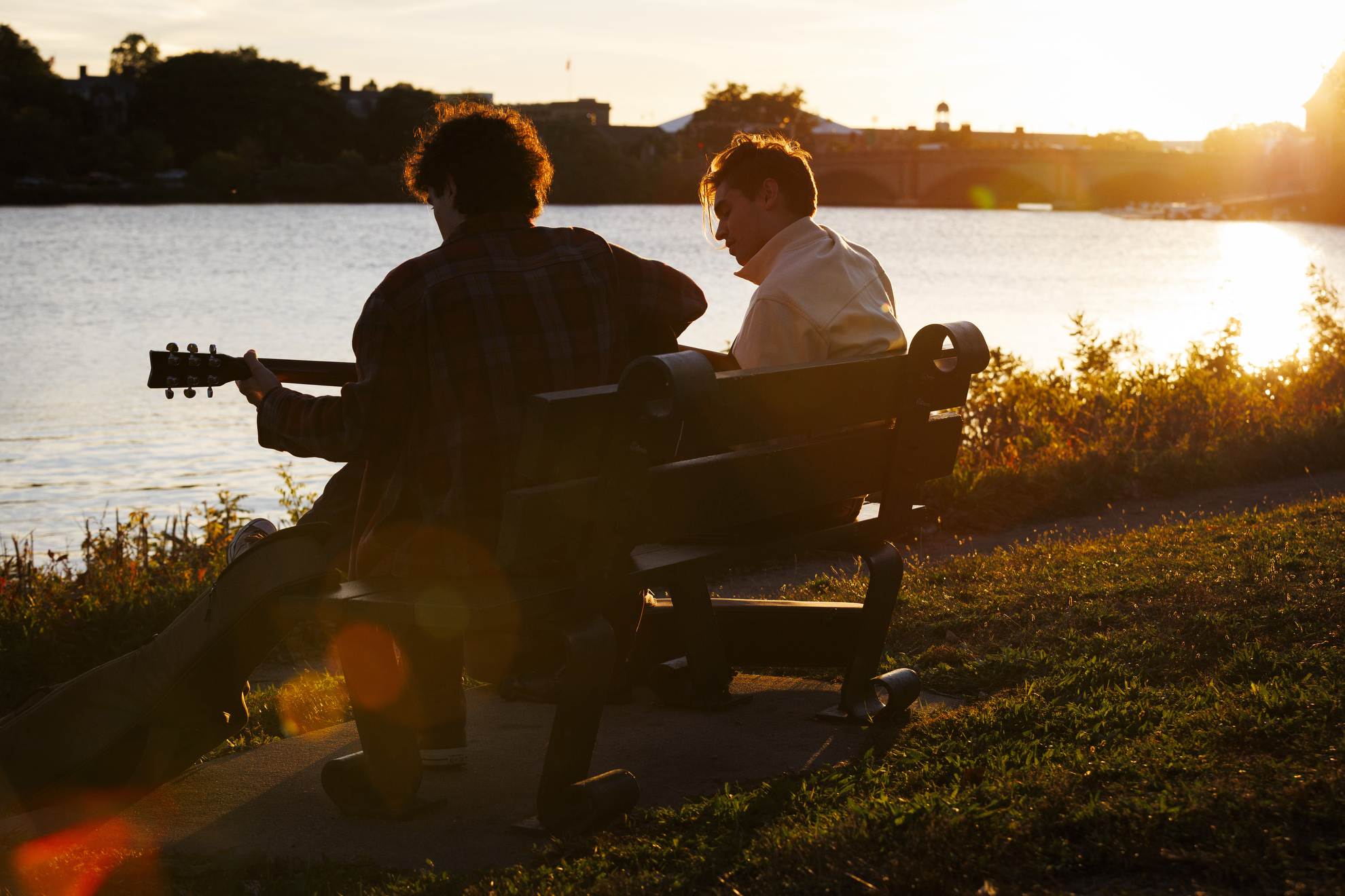 Lorenzo Levy ’27 (left) and Karl Malden ’27 play guitars along the river as the sunsets.