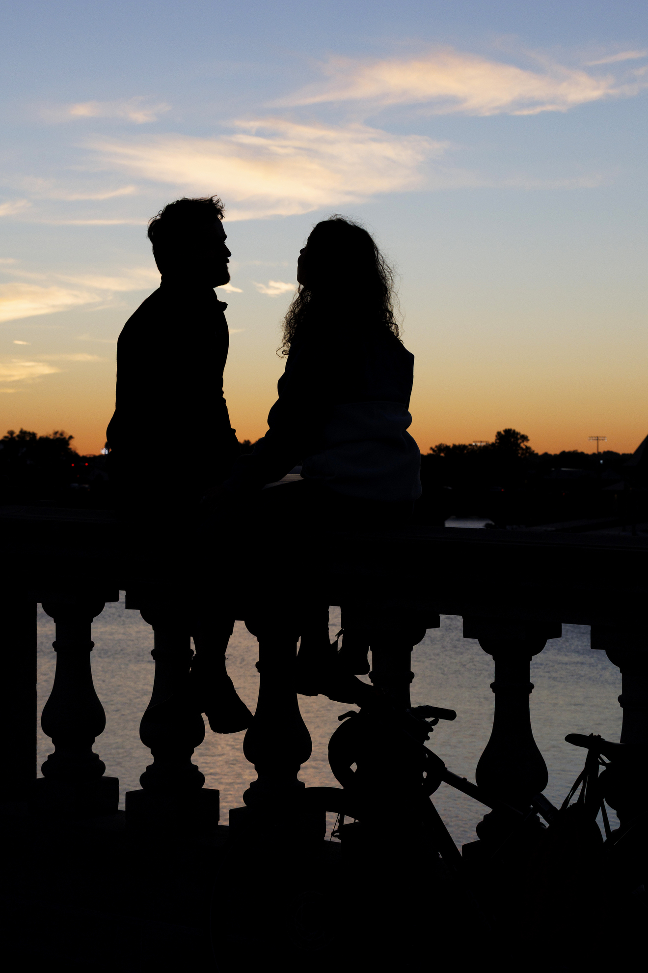 Keaton Stoner (left), resident at Beth Israel Deaconess Hospital, and Paula Ortiz HDS '26 enjoy the sunset perched on the Weeks Footbridge.