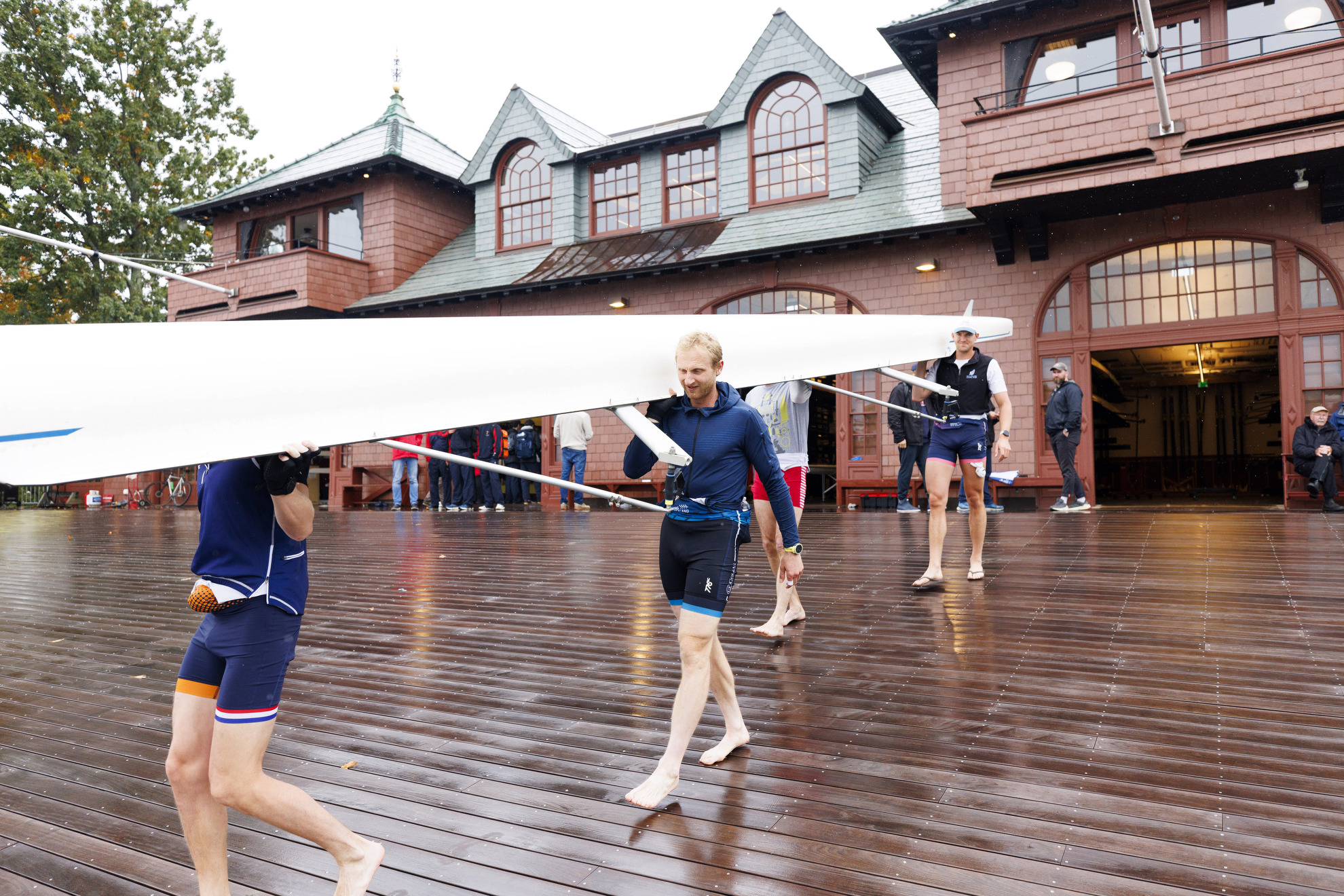 Hamish Bond (center) a three-time Olympic gold medal rower from New Zealand, carries a boat with teammates during a practice session.