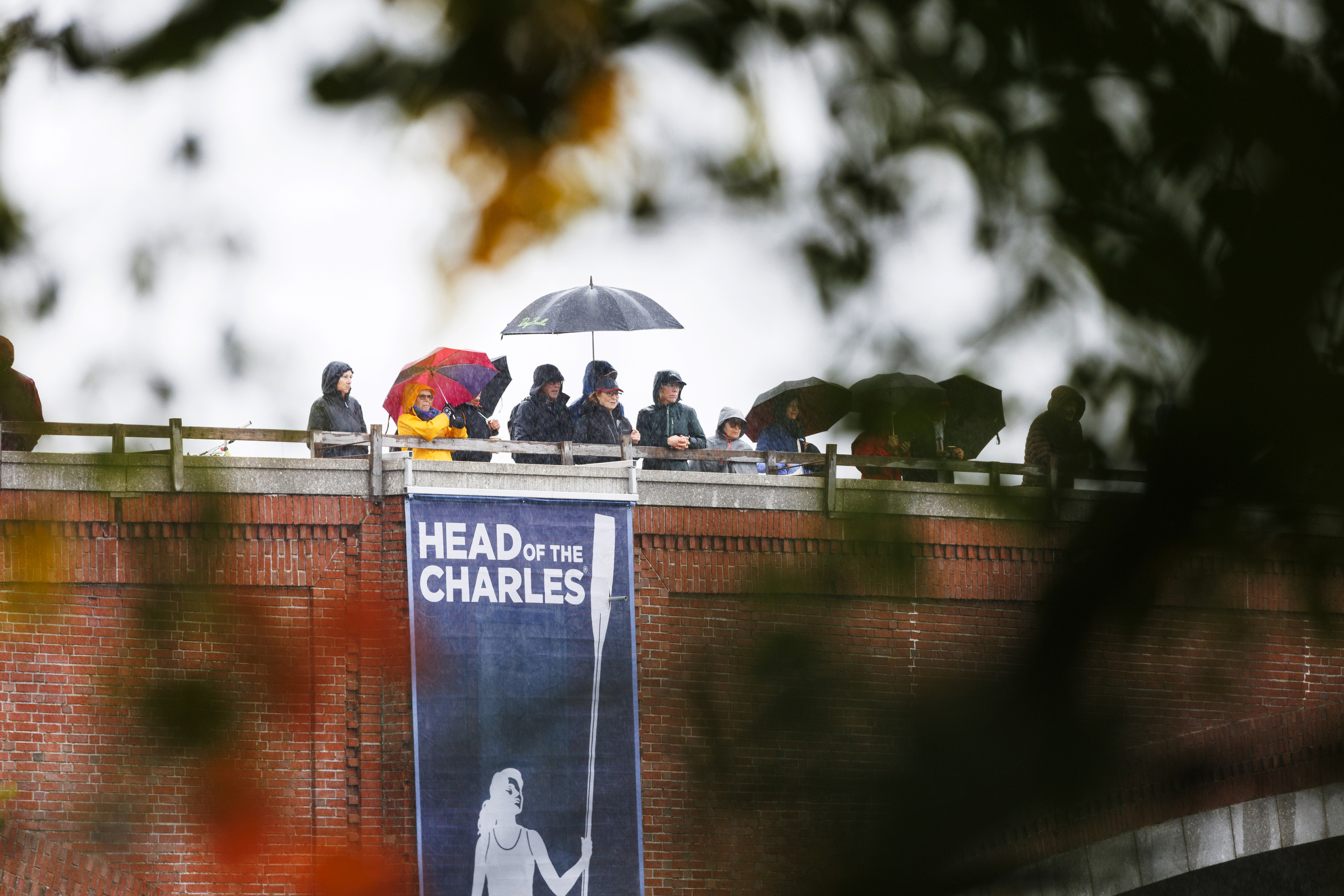 Spectators gathered on Eliot Bridge watch the races from under their umbrellas.