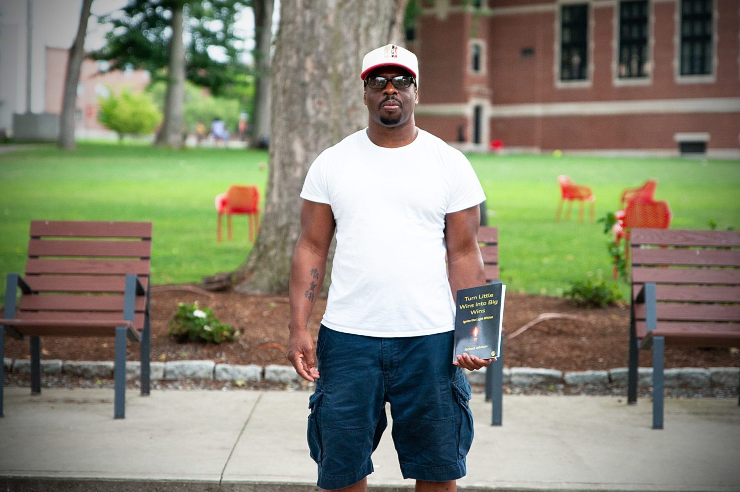 Richard Johnson holds a copy of his book, Turn Little Wins Into Big Wins: Ignite the Light Within You, at Clark University in Worcester. Johnson is a student in Clark University's Liberal Arts for Returning Citizens program.
